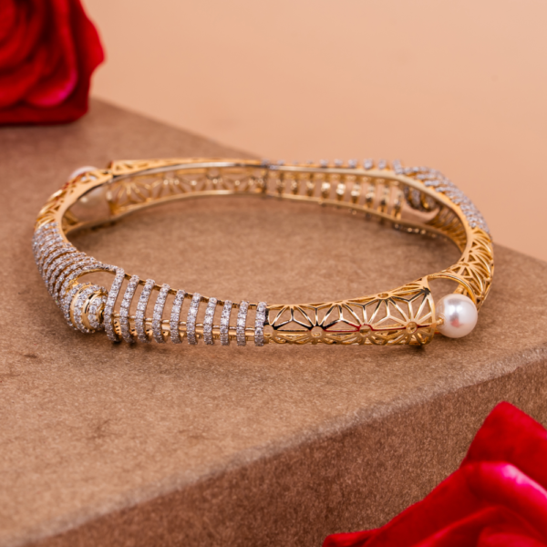 Intricate spiral bangle with pearls and crystal detailing on golden lattice design