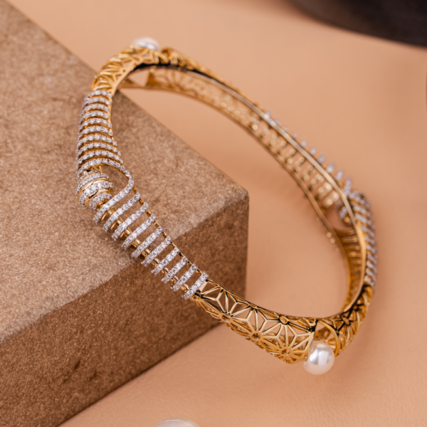 Intricate spiral bangle with pearls and crystal detailing on golden lattice design