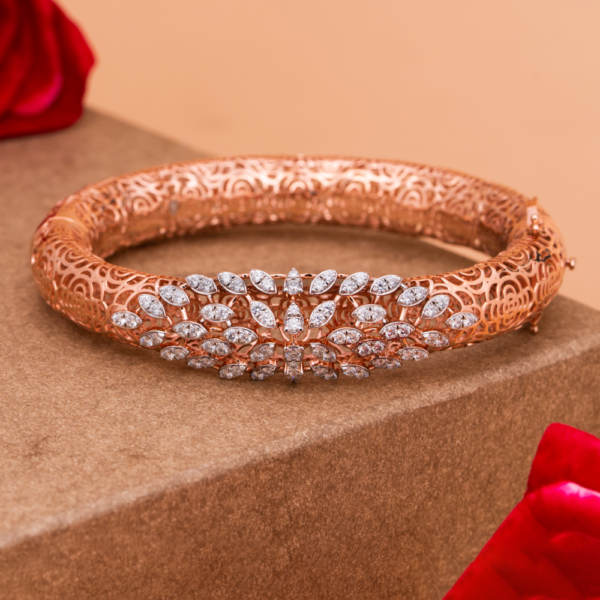 Lunaria Filigree Grace Bangle with intricate floral lattice and petal design on beige background.