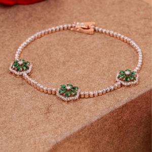 Elegant rose gold bracelet featuring emerald floral motifs encircled with sparkling diamonds, blending nature-inspired design with refined luxury craftsmanship