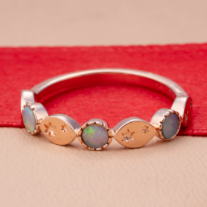 Rose gold opal ring with star-shaped accents inspired by celestial elegance and timeless beauty